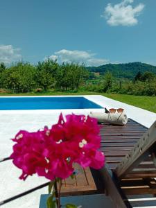 un ramo de flores rosas en una mesa junto a una piscina en Holiday home Residence Green, en Visoko