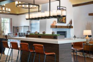a lobby with a bar with chairs and a fireplace at Courtyard by Marriott Santa Barbara Goleta in Santa Barbara
