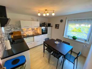 a kitchen and dining room with a table and chairs at Ferienhaus Langweid in Langweid