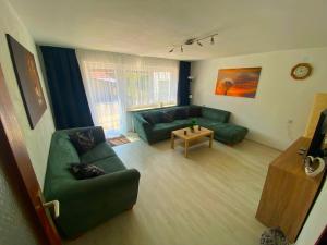 sala de estar con sofá verde y mesa en Ferienhaus Langweid en Langweid