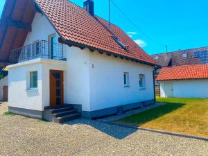 a small white house with a red roof at Ferienhaus Langweid in Langweid