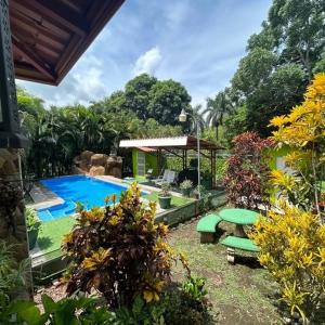 einen Hinterhof mit einem Pool und einem Picknicktisch in der Unterkunft La Esmeralda Villa in Orotina