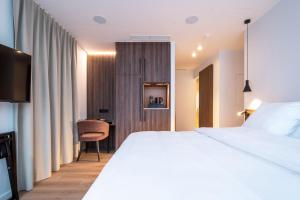 Un pat sau paturi într-o cameră la ONE TWO FOUR - Hotel & Spa