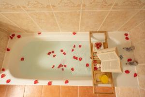 a bath tub with red rose petals on it at The Beach House -South Shields in South Shields