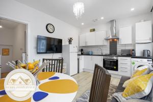 cocina y sala de estar con mesa y sillas en 2 Bed home-Sleeps 5-near station & great location, en Londres