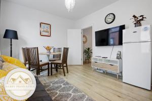 sala de estar con mesa y nevera blanca en 2 Bed home-Sleeps 5-near station & great location, en Londres