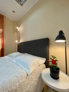 a bedroom with a bed with a table and a lamp at Hostel Good Night in Kharkiv