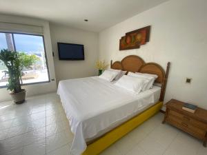 sypialnia z dużym łóżkiem i telewizorem w obiekcie El Peñón, Girardot-Colombia w mieście Girardot