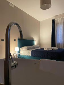 a bedroom with a bed with a green headboard and a mirror at Dimora 7 fontane in Paola