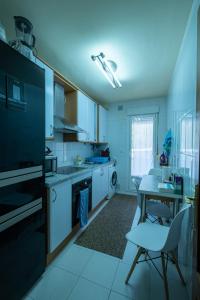 a kitchen with white cabinets and a table and a dining room at La Plata VUT LE 0614 in León