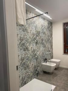 a bathroom with a toilet and a sink with a wallpaper at Dimora 7 fontane in Paola