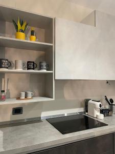 a kitchen with white cabinets and a coffee maker at Dimora 7 fontane in Paola