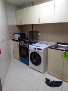 a kitchen with a washing machine and a sink at شقه غرفتين مفروشه in Sharjah