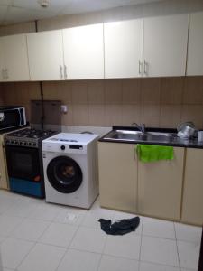 a kitchen with a sink and a washing machine at شقه غرفتين مفروشه in Sharjah