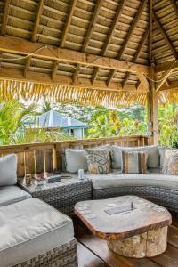 uma área de estar ao ar livre com sofás e uma mesa em Vai Iti Lodge em Afaahiti