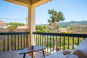 einen Balkon mit einem Sofa und einem Tisch in der Unterkunft Moby Dick Lodge Colares in Colares