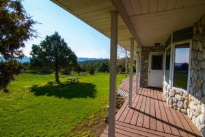a front porch of a house with a picnic table at Fish Hatchery Ranch in Hatch