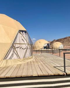 two tents on top of a wooden deck at Wadi Rum Aviva camp in Wadi Rum