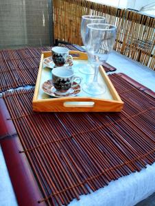 uma bandeja com duas chávenas e um copo de vinho numa mesa em Antonia's cozy apartment em Agia Triada