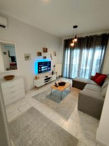 uma sala de estar com um sofá e uma mesa em Antonia's cozy apartment em Hagia Triada