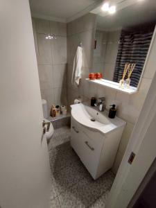 uma casa de banho branca com um lavatório e um WC em Antonia's cozy apartment em Agia Triada