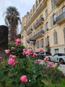 a bunch of pink roses in front of a building at Unique, central et calme in Nice