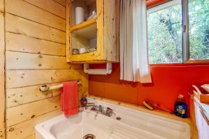 een badkamer met een witte wastafel en een raam bij Cedaredge Lodge, Cabin 3 in Cedaredge