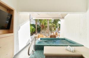 a house with a swimming pool and an umbrella at Bahia Hotel & Beach House in Cabo San Lucas
