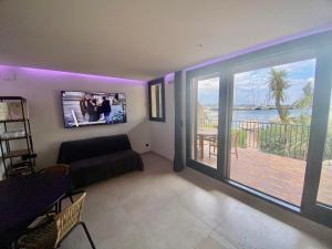 een woonkamer met een bank en een flatscreen-tv bij MarinesAppartement, Le quai Tropézien marina in Saint-Tropez