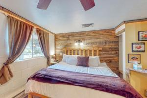1 dormitorio con 1 cama grande y pared de madera en Cedaredge Lodge, Cabin 8 en Cedaredge