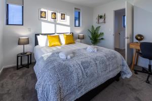a bedroom with a bed with yellow pillows and a desk at 3 bedroom 2 bath Central City in Christchurch
