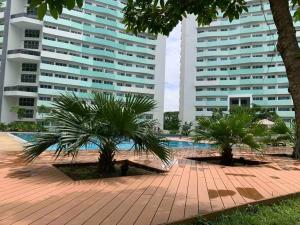 un patio con palmeras frente a dos edificios altos en New Escape (The New staycation in Quezon City), en Manila