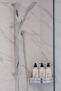 a bathroom with four bottles of soap and a shower at 3 bedroom 2 bath Central City in Christchurch