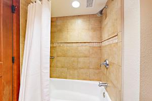 a bathroom with a tub and a shower curtain at 556 Everline in Olympic Valley +16 photos