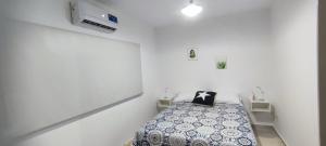 a bedroom with a bed in a white room at ESPACIO UNO in Belén de Escobar
