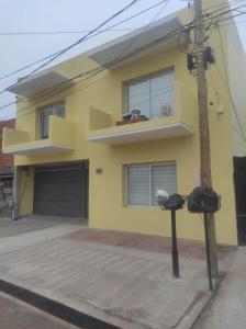 a yellow house with two parking meters in front of it at ESPACIO UNO in Belén de Escobar