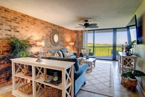 a living room with a couch and a brick wall at Aransas Princess 112 in Port Aransas