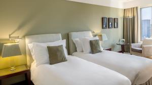 um quarto de hotel com duas camas e uma janela em Crowne Plaza Porto, an IHG Hotel no Porto