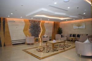 مساكن المنى Al Mona Residences Serviced Apartments في جدة: لوبي وكراسي وطاولة وجدار