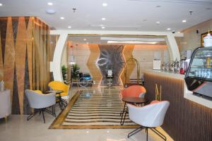 a restaurant with chairs and a bar with a mural at مساكن المنى Al Mona Residences Serviced Apartments in Jeddah