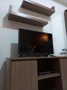 una TV a schermo piatto seduta sopra un centro di intrattenimento in legno di J Room a Pondoktjina 1