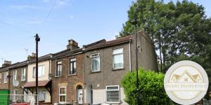 una casa de ladrillo con un cartel delante de ella en 2 Bed home-Sleeps 5-near station & great location, en Londres