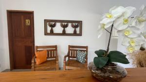 um vaso com flores brancas sentado numa mesa em Pouso Flor da serra em Tiradentes