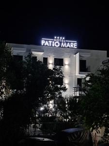 una señal de neón para un edificio de pacato marne por la noche en PATIO MARE, en Dhërmi