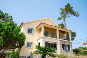 a large yellow house with a balcony at Moby Dick Lodge Colares in Sintra