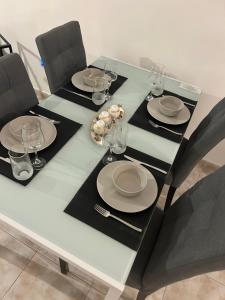 einen Esstisch mit Tellern und Weingläsern darauf in der Unterkunft Cozy Paphos Apartment in Paphos City