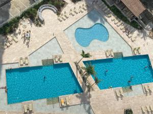 una vista aérea de 2 piscinas en un complejo en apartamento con vista al mar, en Santa Marta
