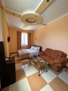 Royal Plus Hotel في يريفان: غرفة معيشة مع سرير وأريكة