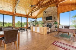 an open living room with a stone fireplace and a television at Soaring High in Pigeon Forge