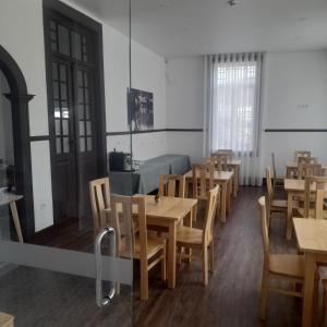 uma sala de jantar com mesas e cadeiras de madeira em DOURO B&B Avenida em Resende